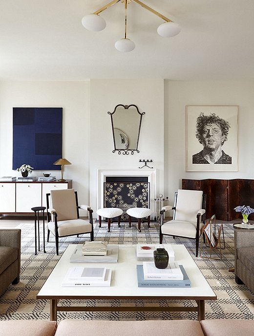 In this Manhattan apartment designed by Alyssa, the abstract painting on one side of the fireplace adds the perfect dash of color, just as the metallic glints of the ceiling light and the lamp atop the credenza contribute an ideal touch of glimmer.
